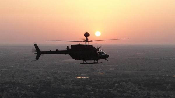 Helicopter flying with sunset behind