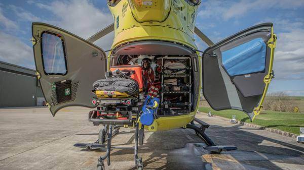 rear of yellow air ambulance with aircrew and equipment