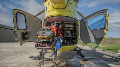 rear of yellow air ambulance with aircrew and equipment