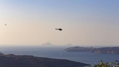 Helicopter flying over sunny seaside location