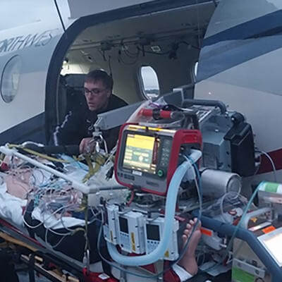 Paramedic helping patient on plane