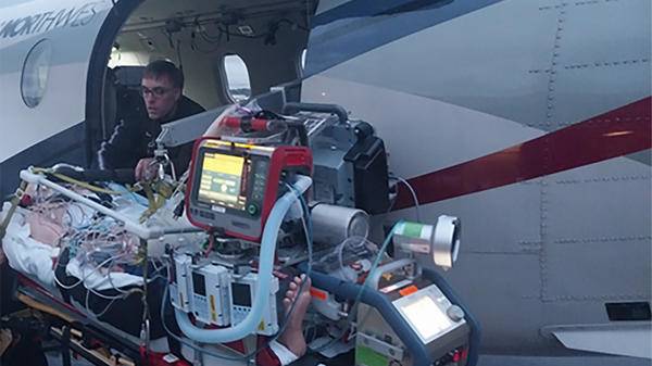 Paramedic helping patient on plane