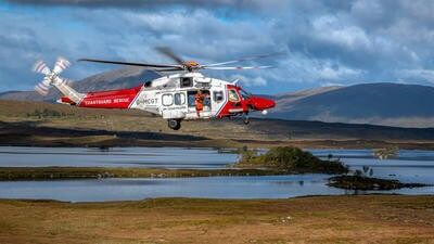 Helicopter with person about to hoist out