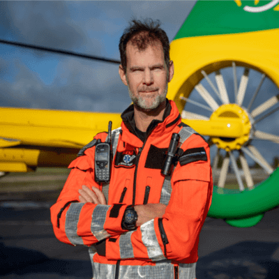 Hampshire and Isle of Wight Air Ambulance worker stood in front of aircraft